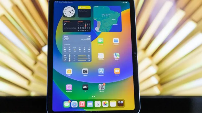 Estudante usando um iPad para fazer anotações em um ambiente de estudos moderno, com o Apple Pencil e livros ao redor.
