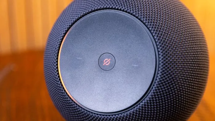 Dispositivo Echo Dot da Alexa em uma mesa, pronto para receber comandos de voz. A imagem mostra a interface de luz azul ativada.