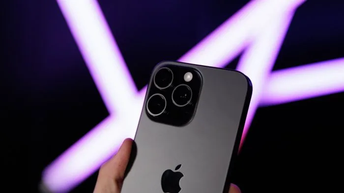Close-up de um iPhone com um sinal estilizado de satélite no canto superior, simbolizando a nova conectividade via satélite da Amazon e Apple.