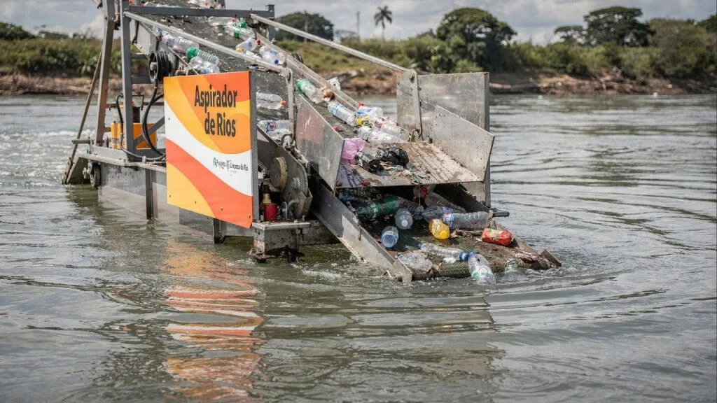 Sistema autônomo com painéis solares coletando lixo em rio, mostrando tecnologia ambiental avançada para combater a poluição.