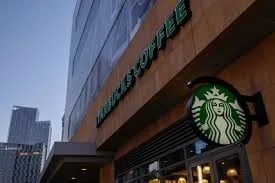Logotipo da Starbucks em uma tela, com um cadeado digital ou símbolos de segurança sobrepostos, representando o ataque cibernético e a violação de segurança.