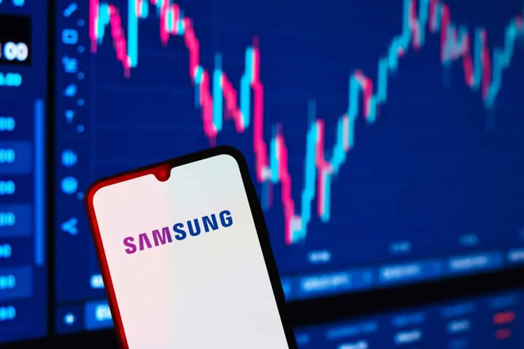 Gráfico financeiro com dados de crescimento e o logo da Samsung em uma tela de smartphone, simbolizando o impacto da demanda por chips.