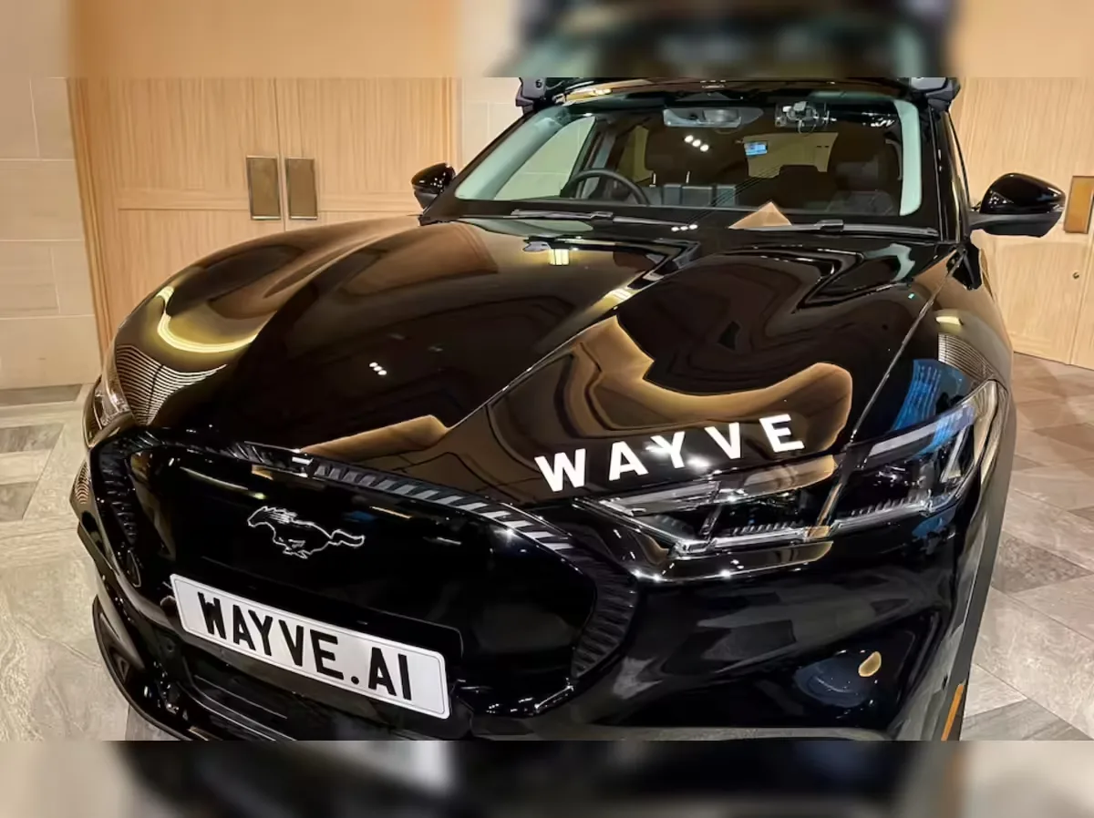 Close-up de painel de carro com piloto automático ativo, exibindo informações digitais e um fundo de estrada borrada.