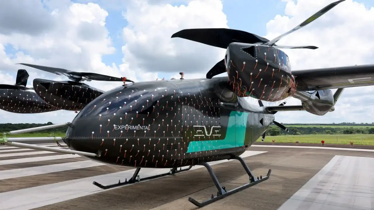 Representação artística de um eVTOL (carro voador) da Eve Air Mobility decolando sobre uma cidade moderna.