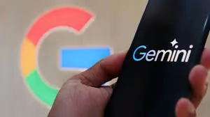 Close-up de um celular exibindo o logotipo do Google Gemini, com um fundo desfocado de diversos aplicativos do Google, simbolizando a integração de dados e a IA personalizada.