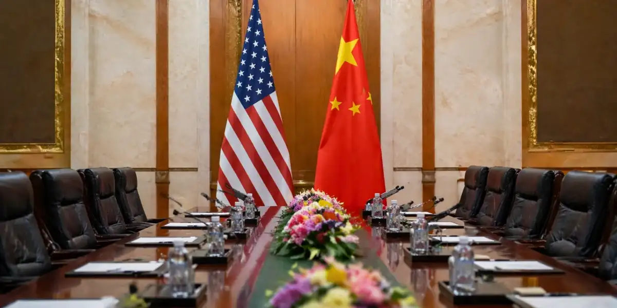 Mãos representando a China e os EUA se estendendo sobre um chip de computador ou um modelo de IA, simbolizando a disputa por tecnologia.