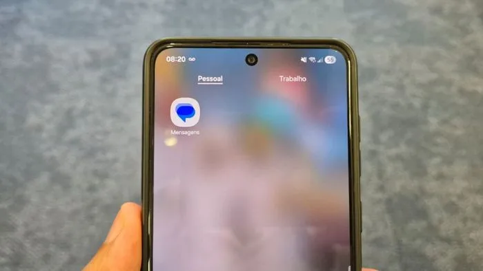Close-up de um celular Android exibindo o aplicativo Google Mensagens, com a tela principal de conversas. Algumas mensagens podem estar faltando ou incompletas, indicando o bug.