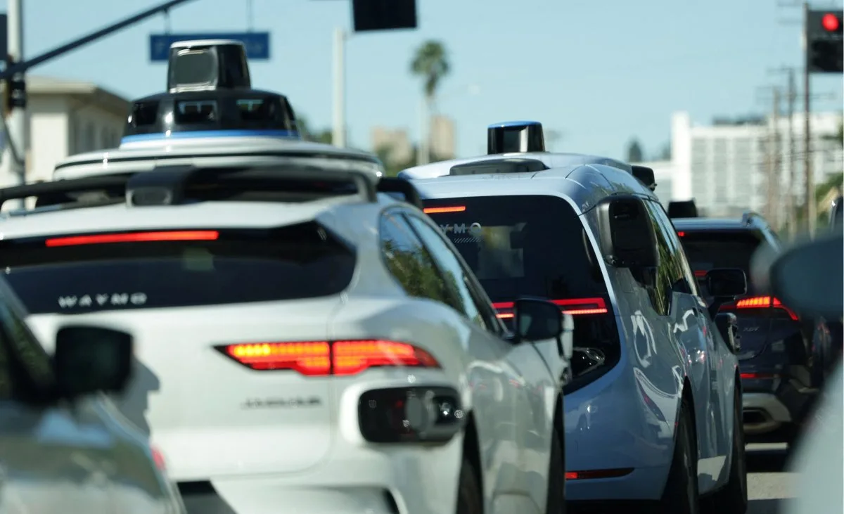 Imagem de um robotáxi futurista circulando pelas ruas de Nova York com o skyline ao fundo, simbolizando a discussão sobre carros autônomos.
