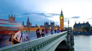 Secretário de Negócios do Reino Unido, Peter Kyle, discursando em um evento, com um fundo corporativo.