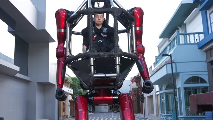 Robô humanoide gigante GD01 da Unitree Robotics com um piloto em seu cockpit, posando em um galpão.