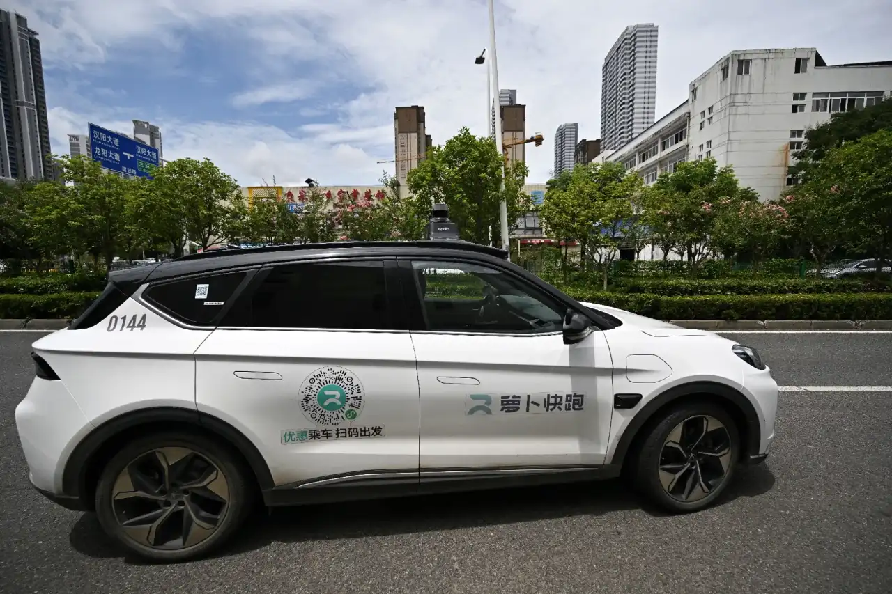 Robôs táxis da Baidu parados na rua após falha de sistema, com luzes de emergência ligadas, em Wuhan, China.