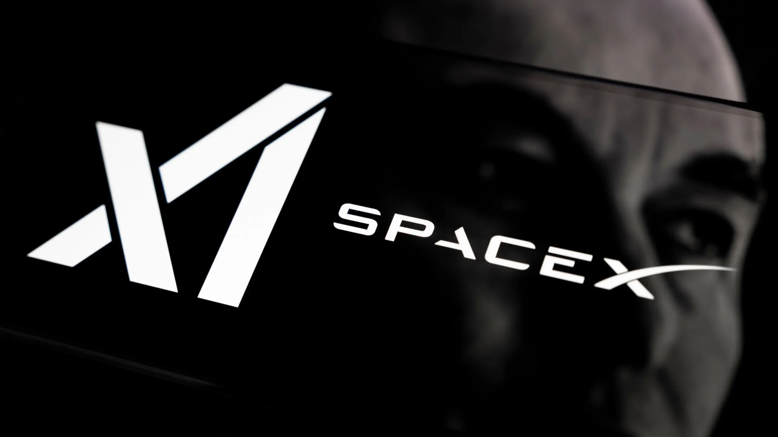Close-up de um chip de computador com a logomarca da SpaceX estilizada, representando a entrada da empresa na fabricação de semicondutores para IA.