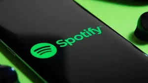 Silhueta de pessoa com projeção da marca Spotify ao fundo, simbolizando a distinção entre criadores humanos e IA.