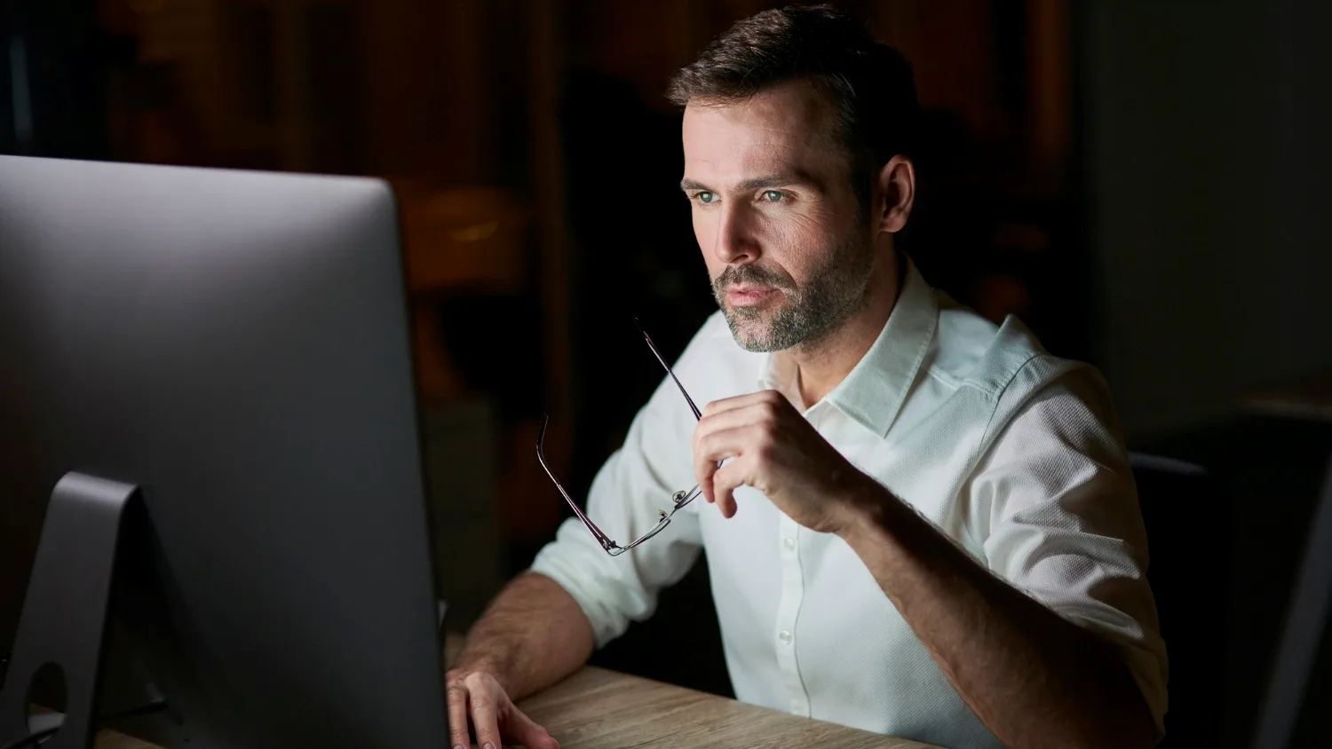 Uma figura digital futurista representando um olho cibernético monitorando um trabalhador remoto em um ambiente de escritório virtual, com grafismos de dados.