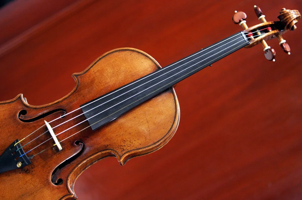 Engenheiros do MIT em laboratório, com um violino virtual sendo exibido em uma tela de computador, representando a fusão entre arte e tecnologia.